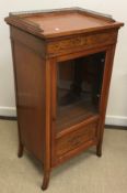 A late Victorian satinwood and marquetry inlaid Sheraton Revival music cabinet with three quarter