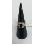 An 18-carat gold emerald cut sapphire and diamond ladies dress ring,