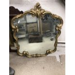 A pair of 20th Century giltwood and gesso framed wall mirrors in the Rococo style with scrolling