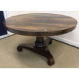 A William IV rosewood breakfast table the circular snap top on a turned pedestal to tripod platform