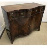 An early 20th Century mahogany serpentine fronted side cabinet in the George III taste with three