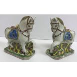 A pair of polychrome glazed faience pottery figures of ceremonial horses with ornate saddles,