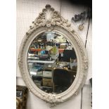 A 20th Century faux marble framed oval wall mirror in the Georgian style with scrolling foliate and