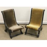 Two Victorian ebonised and gilt or brass embellished nursing chairs of scroll form on scroll