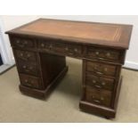 An early 20th Century mahogany double pedestal desk in the Georgian style the tooled and gilded