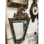 A Continental carved giltwood and gesso framed wall mirror of trapezoid form,