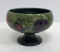 A Moorcroft green ground pansy decorated pedestal bowl raised on a circular foot 15 cm diameter x