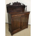 A William IV mahogany chiffonier with carved shelved super structure over a frieze drawer and a