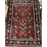 A fine Persian rug, the central panel set with Mirhab design on a red ground,