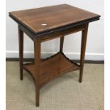 An Edwardian rosewood and cross banded fold over tea table on square tapered legs united by an