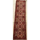 A Persian runner, the central panel set with all-over floral pattern on a cream ground,