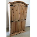 A modern pine two door wardrobe of armoire form,