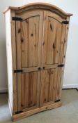 A modern pine two door wardrobe of armoire form,