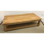 A modern oak two tier coffee table on square supports 160 cm wide x 80 cm x 40 cm high