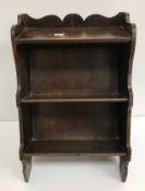 An early 20th Century leather bound miniature bookcase containing reference library books including