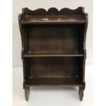 An early 20th Century leather bound miniature bookcase containing reference library books including