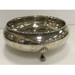 A sterling silver bowl with applied decoration raised on three claw feet stamped "Sterling silver"