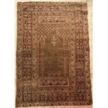 A vintage Ushak prayer rug, the central panel set with Mirhab design on a green ground,