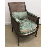 A circa 1900 mahogany framed and double caned Bergere armchair in the Regency style with guilloche,