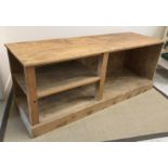 A 20th Century pine kitchen or shop unit, the plain top above an open recess and shelf,