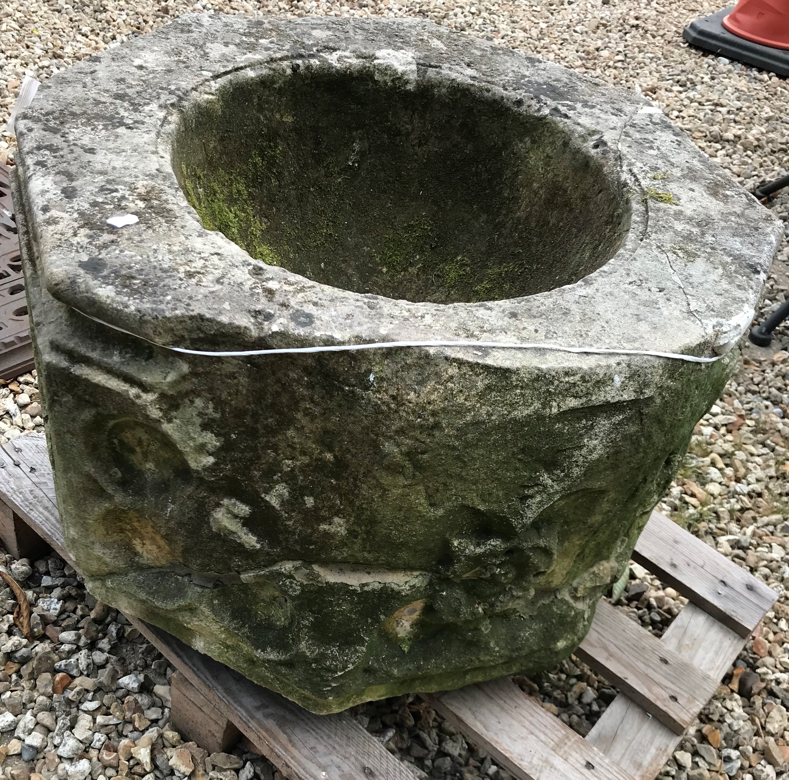 A natural stone font of octagonal form with rose decoration to each side height 45cm width 63cm