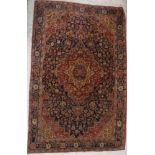 A Kashan rug, the central panel set with floral decorated medallion on a blue,