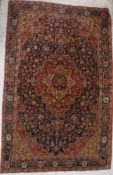 A Kashan rug, the central panel set with floral decorated medallion on a blue,