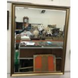A wooden framed wall mirror with applied leaf decoration with plain rectangular plate 89 cm x 134