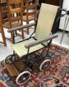 A vintage wrought iron framed Leeway folding wheelchair, with canvas seat,