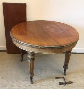 A Victorian mahogany circular D end dining table with single extra leaf,