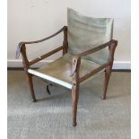 A circa 1900 teak framed campaign chair with leather strap arms and canvas seat and back,