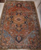 A Persian rug, the central panel set with stylised flower head medallion on a rust,