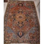 A Persian rug, the central panel set with stylised flower head medallion on a rust,