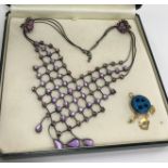 A modern costume jewellery necklace set with purple coloured stones in a lattice design with