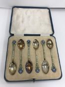 A cased set of six George V silver and enamel decorated coffee spoons,