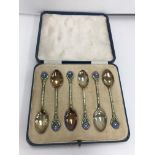 A cased set of six George V silver and enamel decorated coffee spoons,