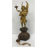 An 18th Century style Continental gilt bronze pricket candlestick as a cherub holding aloft two