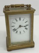A circa 1900 brass cased carriage clock, the enamelled dial with Roman numerals,