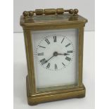 A circa 1900 brass cased carriage clock, the enamelled dial with Roman numerals,