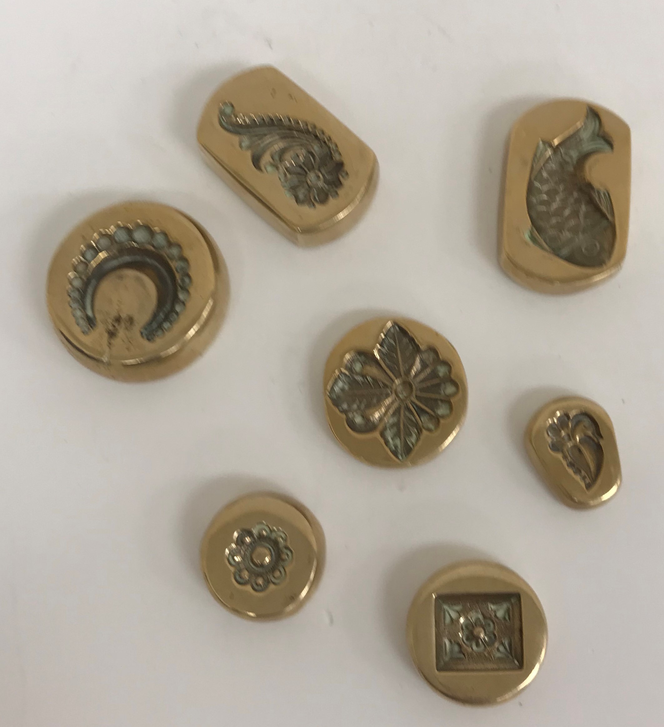 A collection of seven brass moulds, probably for jewellery and Indian,