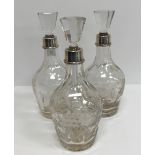 A set of three mallet-shaped cut glass decanters with fruit, floral and facet decoration,