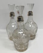 A set of three mallet-shaped cut glass decanters with fruit, floral and facet decoration,