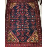 A Caucasian rug, the central panel set with stylised floral decoration on a blue ground,