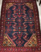 A Caucasian rug, the central panel set with stylised floral decoration on a blue ground,