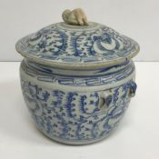 An Oriental blue and white decorated lidded pot with twin handles 22 cm high x 20 cm diameter