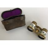 A pair of early 20th Century enamel decorated opera glasses with mother of pearl mounts,