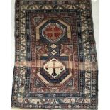 A vintage Shirvan rug, the cental panel set with two medallions on a blue and cream ground,