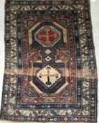 A vintage Shirvan rug, the cental panel set with two medallions on a blue and cream ground,