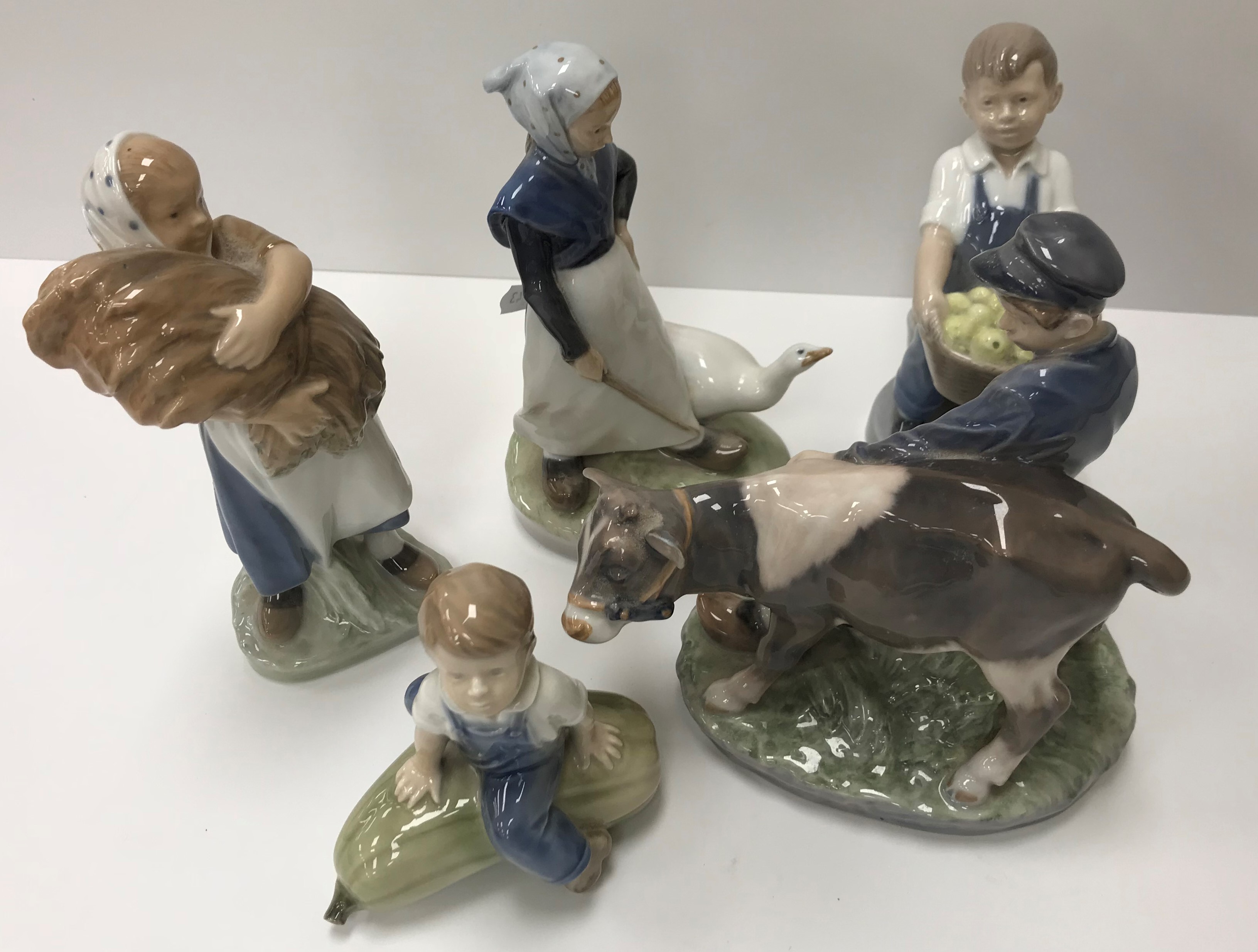 A collection of five various Royal Copenhagen figures including "Boy with calf" (772),