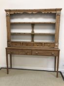 A Victorian pine three tier plate rack with cup hooks over four drawers,